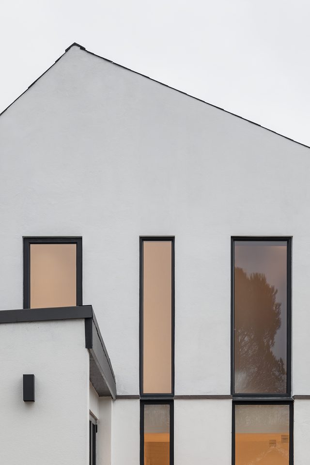 White rendered gable with slender dark-framed windows